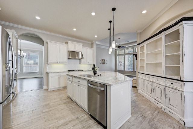 kitchen featuring a center island with sink, sink, appliances with stainless steel finishes, decorative light fixtures, and white cabinetry