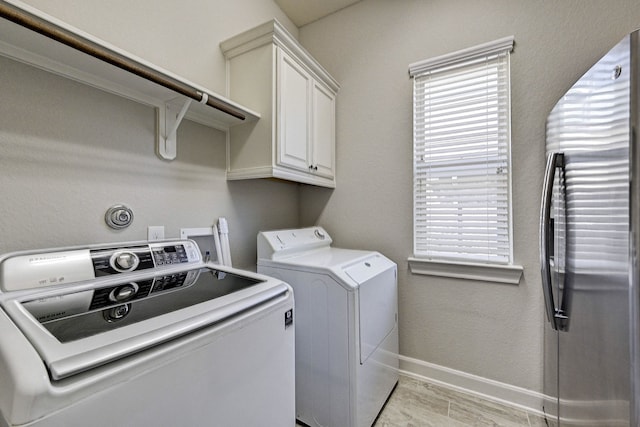 washroom featuring cabinets and separate washer and dryer