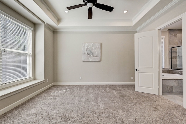 carpeted spare room featuring ceiling fan, a raised ceiling, and ornamental molding