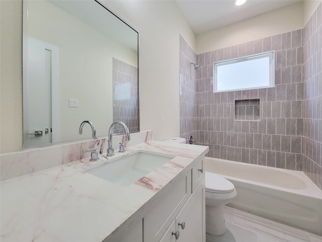 full bathroom with vanity, tiled shower / bath combo, and toilet