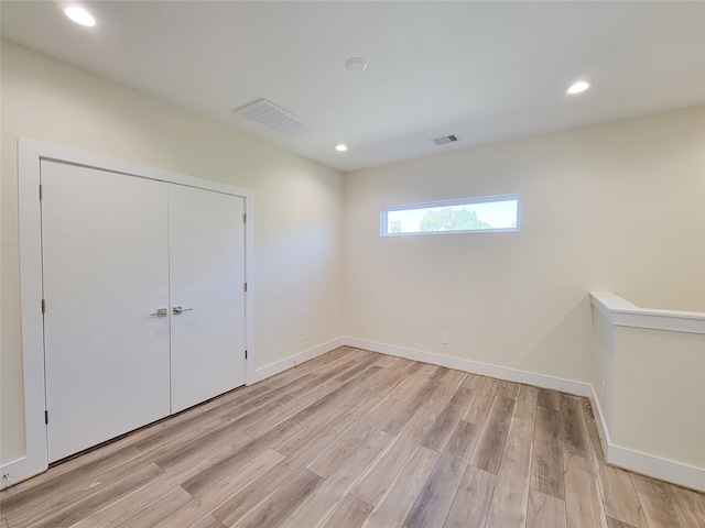 unfurnished bedroom with a closet and light wood-type flooring