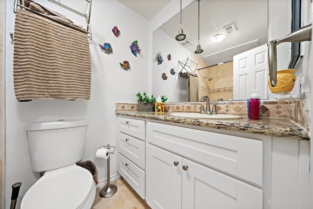 bathroom with vanity, toilet, and decorative backsplash