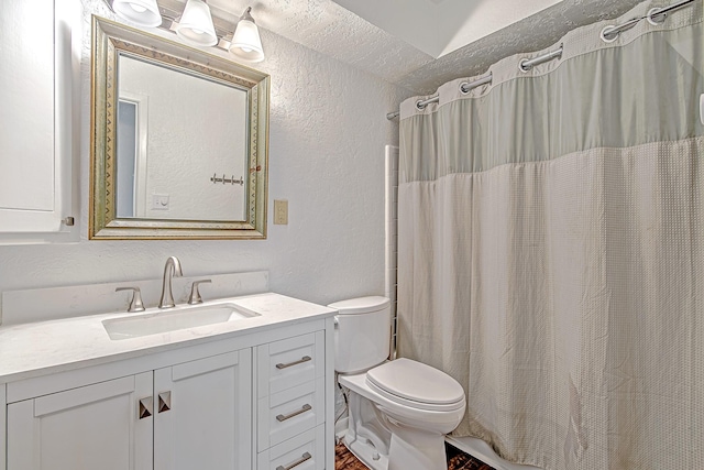 bathroom with curtained shower, a textured wall, vanity, and toilet