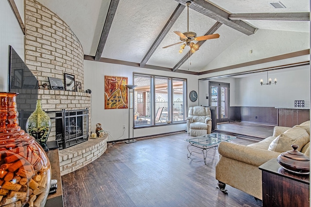 living room with vaulted ceiling with beams, a fireplace, visible vents, a textured ceiling, and wood finished floors