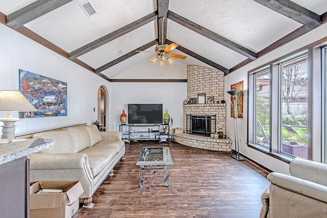 living room with arched walkways, visible vents, dark wood finished floors, and a fireplace