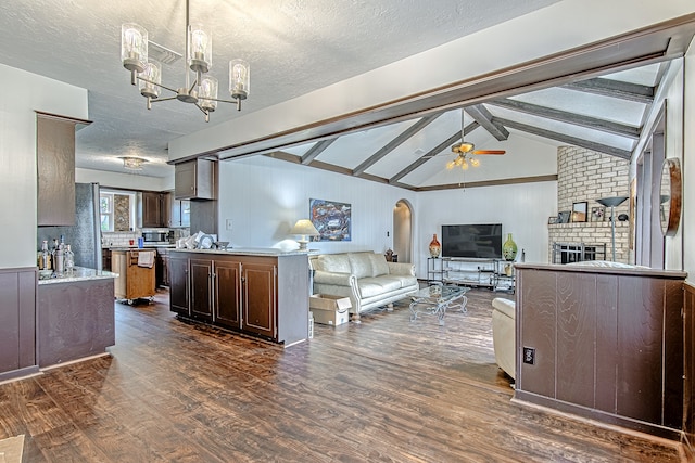 kitchen with dark hardwood / wood-style flooring, ceiling fan with notable chandelier, a center island, dark brown cabinetry, and vaulted ceiling with beams