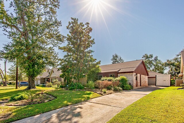 view of front of house featuring a garage, a front yard, and brick siding