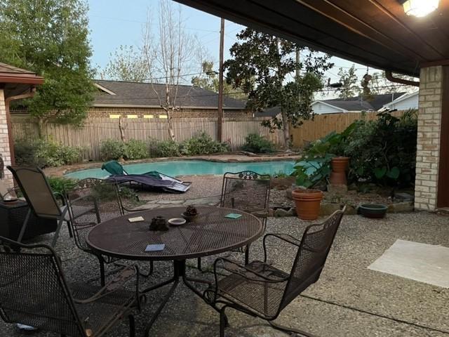 view of patio featuring a fenced in pool, outdoor dining space, and a fenced backyard