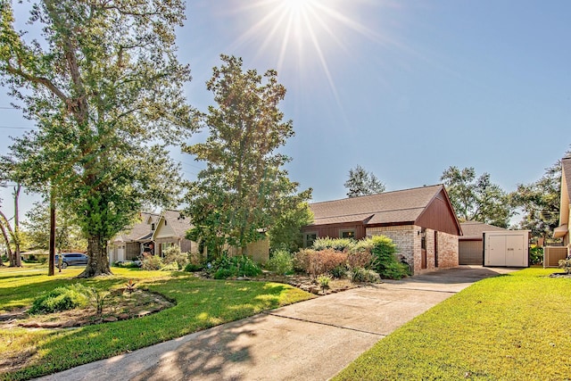 view of front facade featuring a front yard, brick siding, and a detached garage