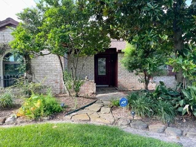 view of exterior entry featuring brick siding