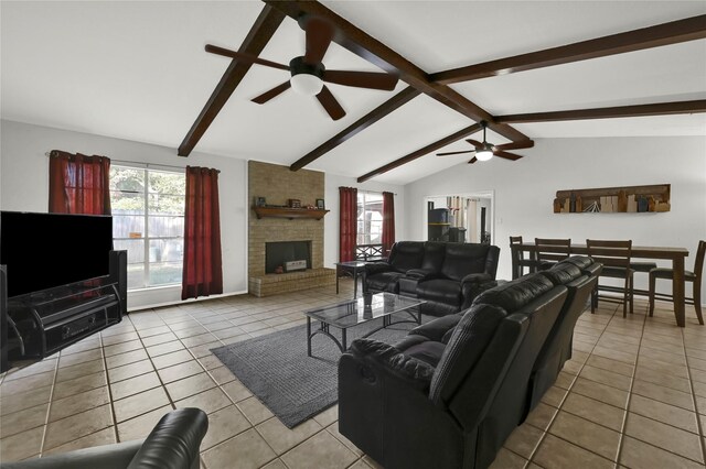 living room featuring lofted ceiling with beams, a brick fireplace, ceiling fan, and light tile patterned flooring