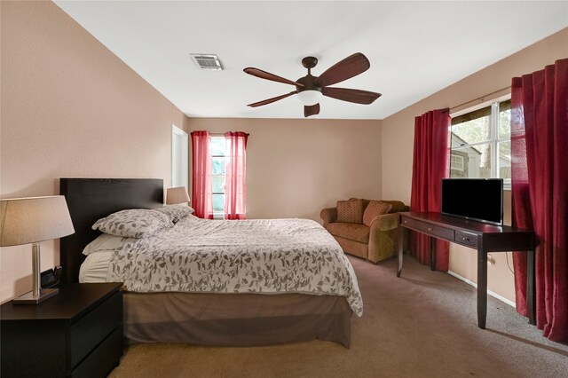 carpeted bedroom with multiple windows and ceiling fan