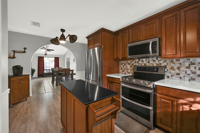 kitchen featuring backsplash, light hardwood / wood-style flooring, and appliances with stainless steel finishes