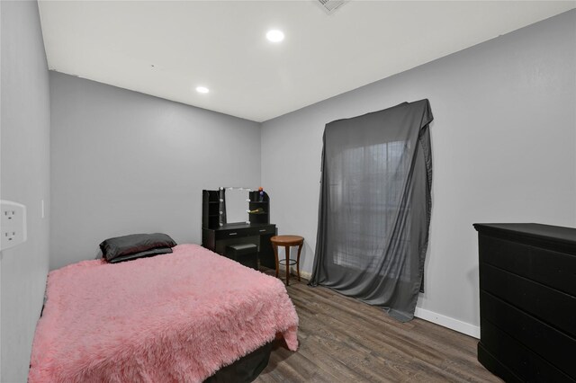 bedroom with dark hardwood / wood-style floors