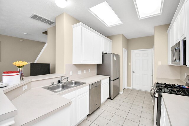 6059 Shelbourne Park Ln, Houston, TX 77084 - kitchen with stainless steel appliances, a sink, white cabinetry, and light tile patterned floors