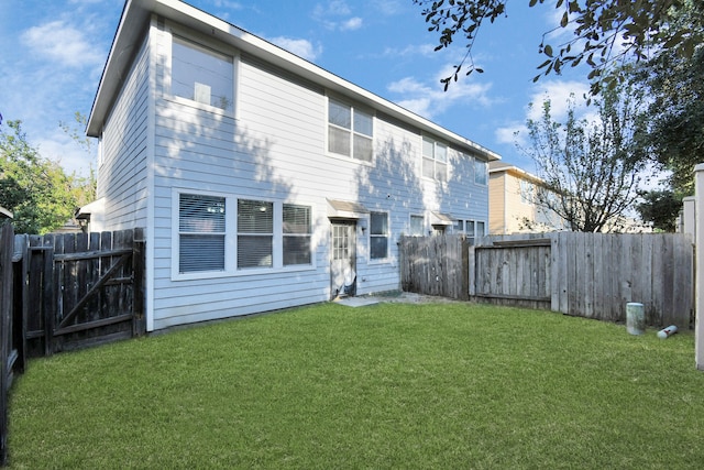 rear view of property featuring a lawn