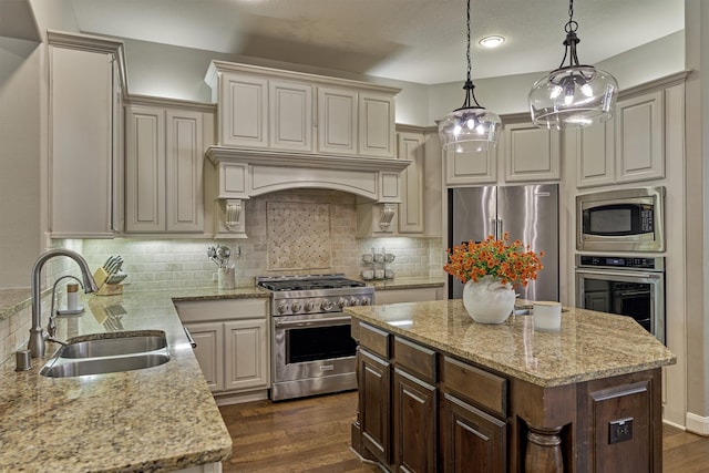 kitchen with decorative light fixtures, sink, high end appliances, and dark hardwood / wood-style floors