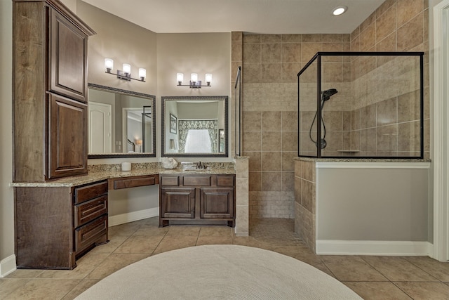 bathroom with vanity, tiled shower, and tile patterned floors