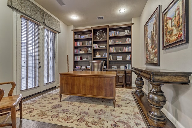 office space with french doors, a textured ceiling, and light wood-type flooring