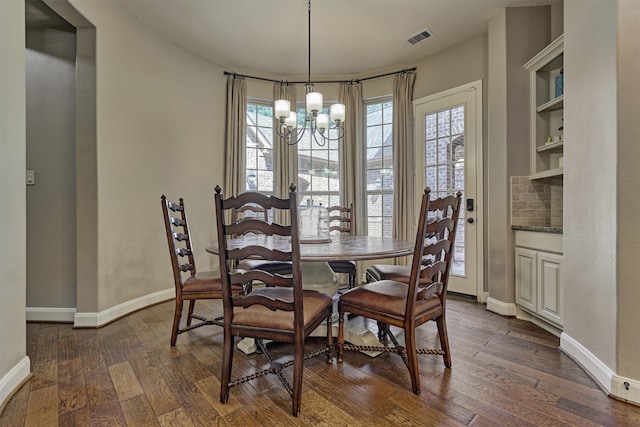 dining room with a notable chandelier and dark hardwood / wood-style flooring