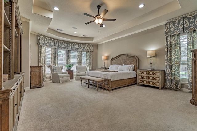 carpeted bedroom featuring ornamental molding, a tray ceiling, and ceiling fan