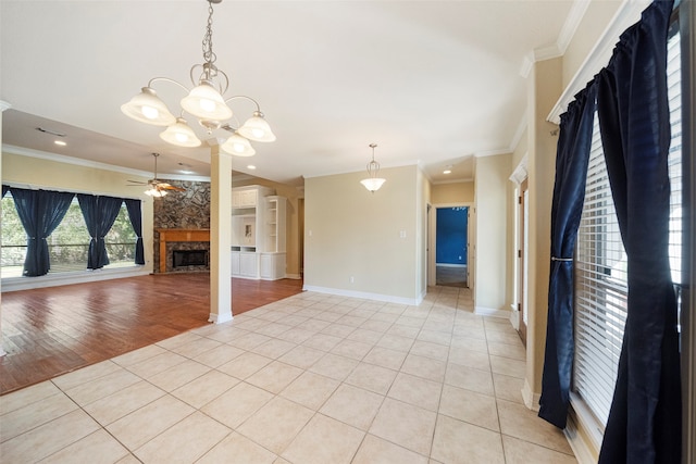 unfurnished living room featuring crown molding, light hardwood / wood-style flooring, a fireplace, and ceiling fan with notable chandelier