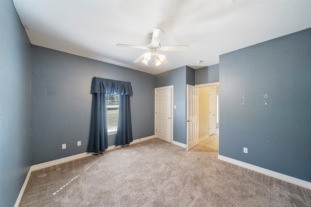 unfurnished bedroom with ceiling fan and light colored carpet