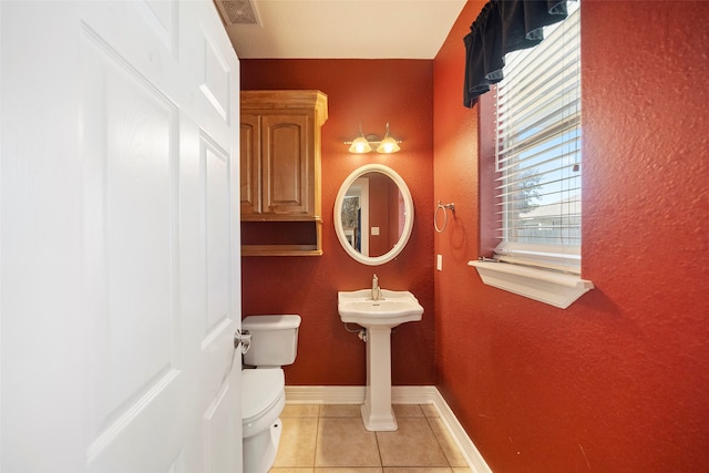 bathroom with toilet and tile patterned flooring