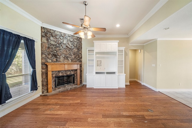 unfurnished living room featuring ornamental molding, hardwood / wood-style flooring, a fireplace, and ceiling fan