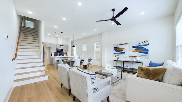 living room featuring ceiling fan and light hardwood / wood-style flooring