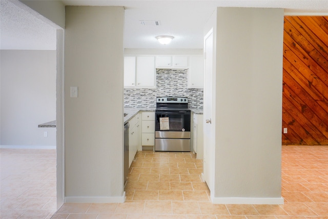 kitchen with white cabinetry, backsplash, appliances with stainless steel finishes, and light tile patterned floors