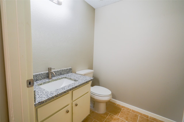 bathroom with vanity, toilet, and tile patterned flooring