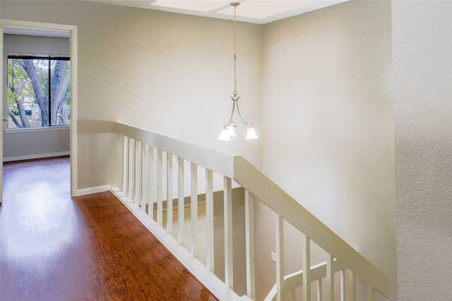 corridor with a notable chandelier and wood-type flooring