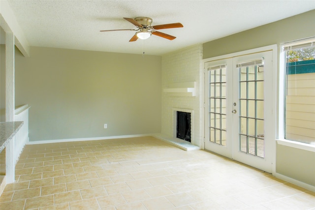 unfurnished living room with ceiling fan, a textured ceiling, light tile patterned flooring, a fireplace, and french doors