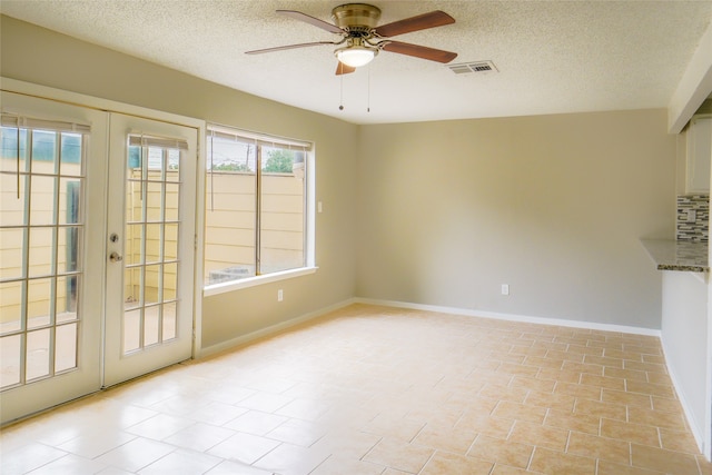 unfurnished room featuring french doors, a textured ceiling, and ceiling fan