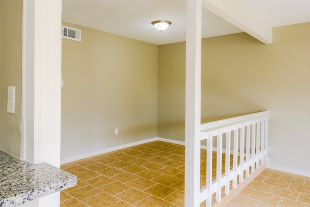 interior space with a textured ceiling and tile patterned floors