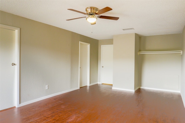 unfurnished bedroom with a closet, ceiling fan, a textured ceiling, and dark hardwood / wood-style floors