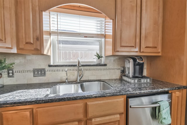 kitchen with dark stone counters, a healthy amount of sunlight, sink, and stainless steel dishwasher