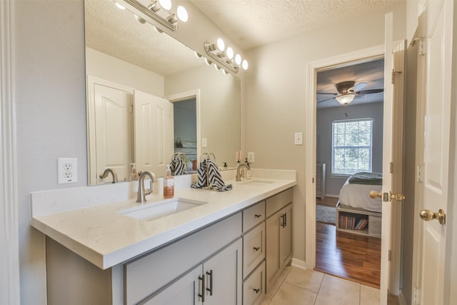 bathroom featuring tile patterned floors, vanity, ceiling fan, and a textured ceiling