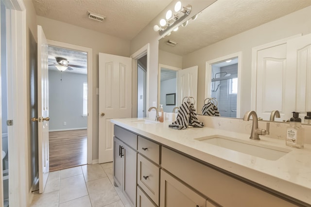 bathroom with tile patterned floors, vanity, a textured ceiling, ceiling fan, and a shower with shower door