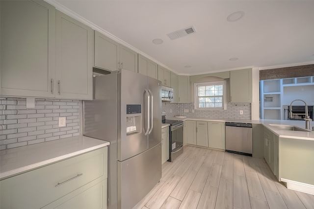 kitchen featuring backsplash, stainless steel appliances, sink, and light hardwood / wood-style floors