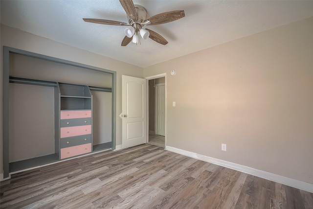 unfurnished bedroom featuring wood-type flooring, a closet, and ceiling fan