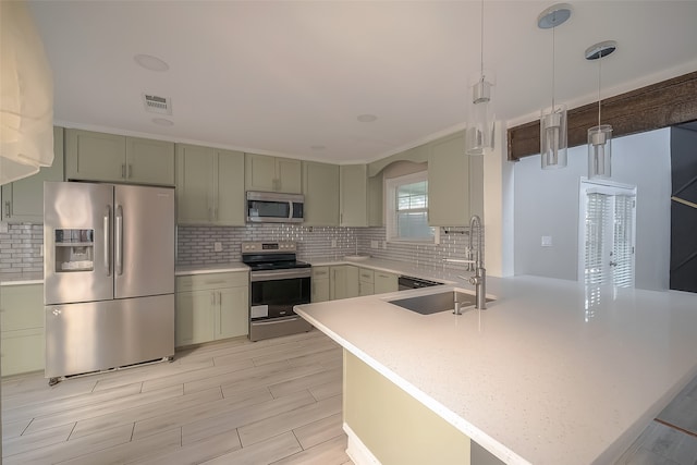 kitchen with kitchen peninsula, stainless steel appliances, sink, decorative light fixtures, and tasteful backsplash