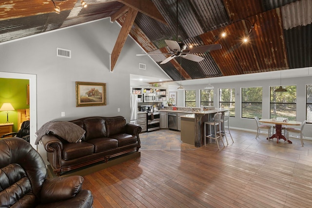 living room featuring beam ceiling, wood-type flooring, high vaulted ceiling, and ceiling fan