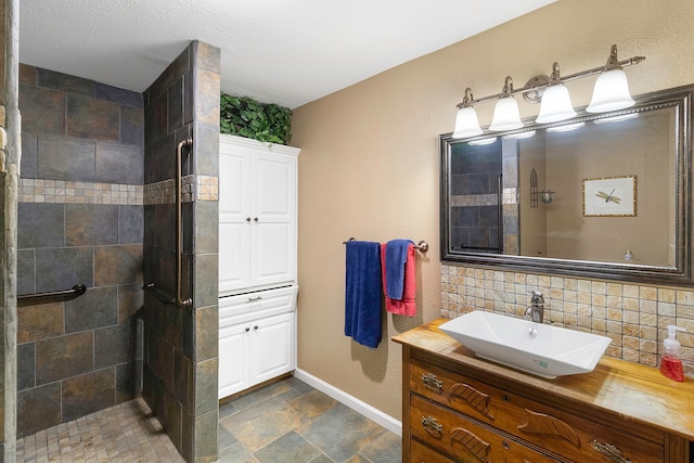 bathroom featuring vanity, a tile shower, a textured ceiling, and tasteful backsplash