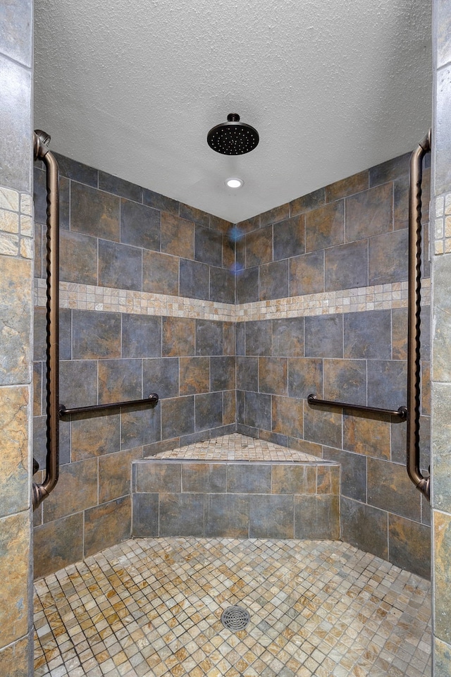 bathroom featuring an enclosed shower and a textured ceiling