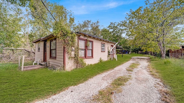 view of side of home with a yard