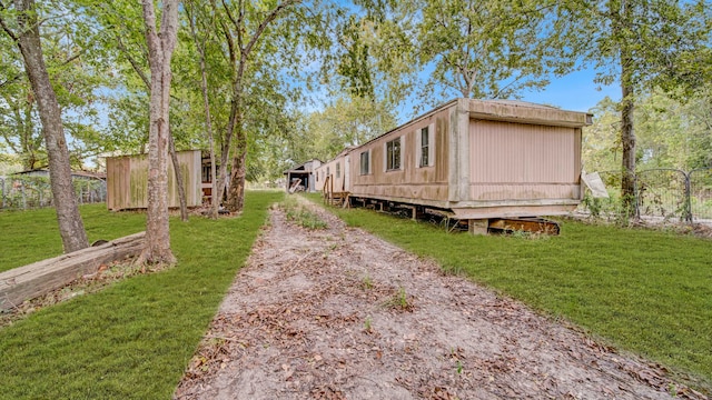 view of property exterior with a lawn and an outdoor structure