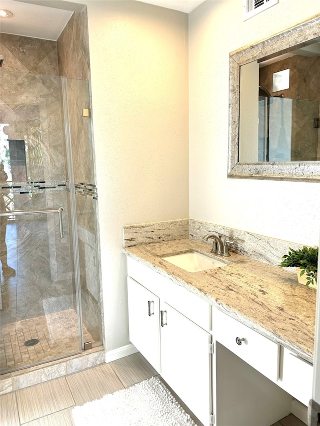 bathroom featuring vanity and a shower with shower door