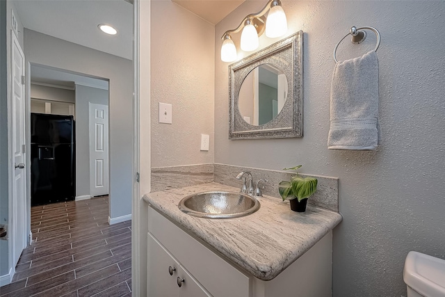 2333 Bering Dr Unit 139, Houston, TX 77057 - bathroom featuring vanity, wood finish floors, toilet, baseboards, and a textured wall